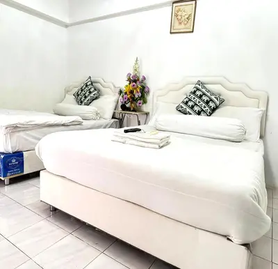 two beds in a room with white walls at ATHIVAT Royal Pratunam in Bangkok