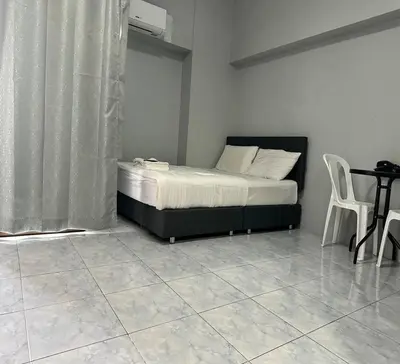 a bedroom with a bed and a table and chairs at ATHIVAT Royal Pratunam in Bangkok