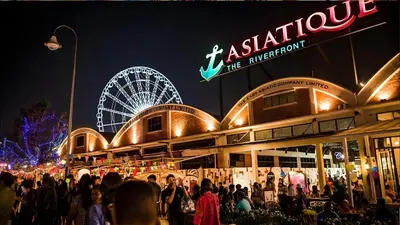 a crowd of people standing outside a building with a ferris wheel at XX GO INN Asiatique Bangkok โก อินน์ เอเชียทีค เจริญกรุง in Bangkok