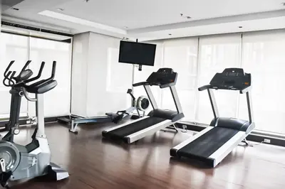 a gym with cardio machines and a flat screen tv at Executive Suite 2 Beds Nana BTS 5 mins in Bangkok