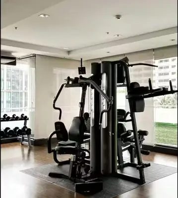 a gym with treadmills and chairs in a room at Executive Suite 2 Beds Nana BTS 5 mins in Bangkok