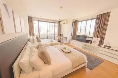 a large bedroom with two beds and a flat screen tv at Executive Suite 2 Beds Nana BTS 5 mins in Bangkok