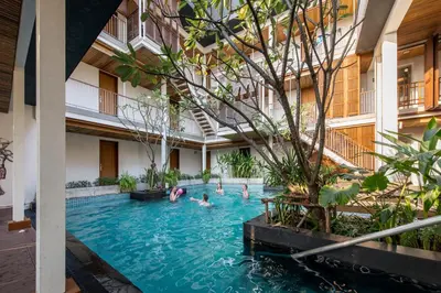 a group of people swimming in a pool in a building at Nanda Heritage Hotel in Bangkok