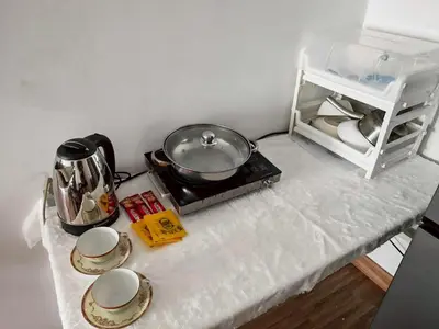a kitchen counter with a stove with a pot and dishes at Laid back at IRIS Westgate Bangkok-Nonthaburi in Ban Bang Phai