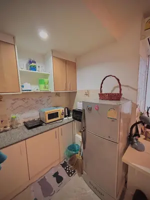 a small kitchen with a refrigerator and a microwave at Modern Condo with Full Amenities Bangkok in Sathani Ban Hua Mak