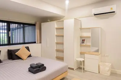 a bedroom with a bed and a desk in it at Lovely Townhome in Shopping District near BTS&MRT in Bang Su