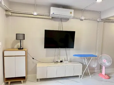 a living room with a tv on a wall at Lovely Townhome in Shopping District near BTS&MRT in Bang Su