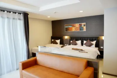 a hotel room with a bed and a chair at Picnic Hotel Bangkok - Rang Nam in Bangkok