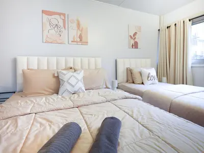 a bedroom with two beds with their legs on it at Cozy 2BR Near Impact Arena, LTAT- WiFi Washer near DMK at C2 in Ban Song Hong