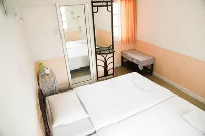 a small room with a bed and a mirror at White Lodge Hotel Bangkok in Bangkok