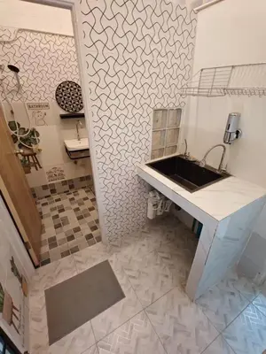 a bathroom with a sink and a tile floor at Charoen Nakhon 48 House in Godown