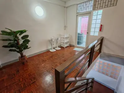 a room with a staircase and a potted plant at Charoen Nakhon 48 House in Godown