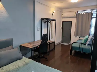 a bedroom with a desk and a bed and a chair at Charoen Nakhon 48 House in Godown