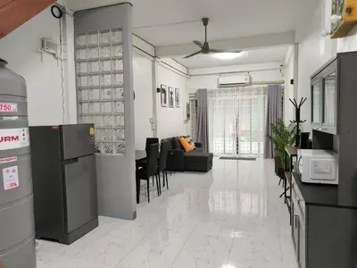 a kitchen and living room with a couch and a table at Charoen Nakhon 48 House in Godown