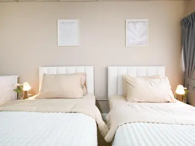 two beds sitting next to each other in a bedroom at Cozy 2BR for 4 persons, Impact,Wi-Fi & Washer, DMK in Bangkok