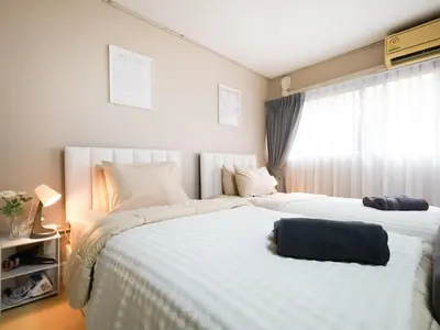a bedroom with two beds and a window at Cozy 2BR for 4 persons, Impact,Wi-Fi & Washer, DMK in Bangkok