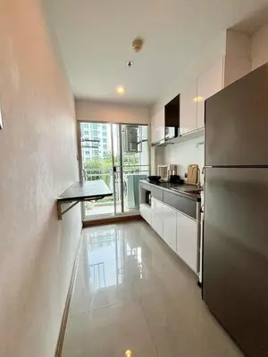 a kitchen with a refrigerator and a table in it at Supalai Wellington 2 Near MRT in Bangkok