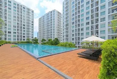 a swimming pool with an umbrella and some buildings at Supalai Wellington 2 Near MRT in Bangkok