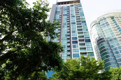 a tall building with trees in front of it at Luxury room close to BTS in Bangkok