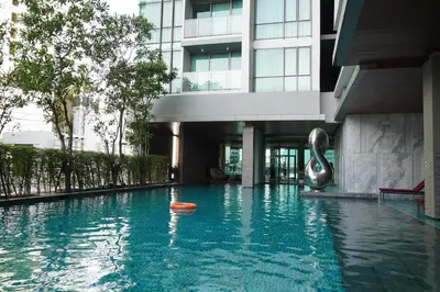 a swimming pool in front of a building at Luxury room close to BTS in Bangkok