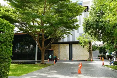 a tree in front of a building with orange cones at Luxury room close to BTS in Bangkok