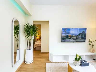 a living room with a tv on a white wall at 2 Bedroom for 3 guests in heart Sathorn with Balcony in Bangkok