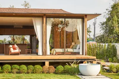 a guest house with a master bedroom in the backyard at Chobjai Hostelry - Chaw Cher Home at Bang Kra Jao in Bang Krasop