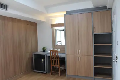 a room with a desk and a closet with a chair at Bangkok Place Apartment - EKAMAI BTS in Bangkok