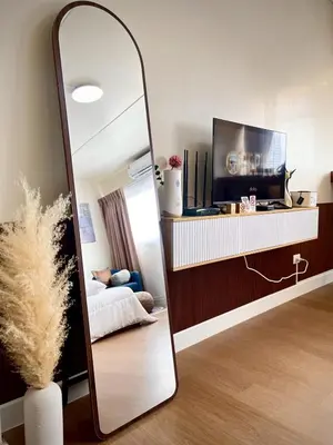 a mirror in a room with a bed and a tv at Happy House T8 in Thung Si Kan