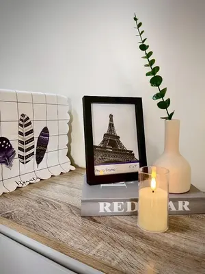a candle on a table with a picture of the eiffel tower at Happy House T8 in Thung Si Kan