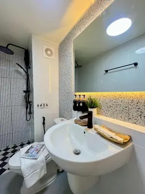 a bathroom with a white sink and a toilet at Happy House T8 in Thung Si Kan