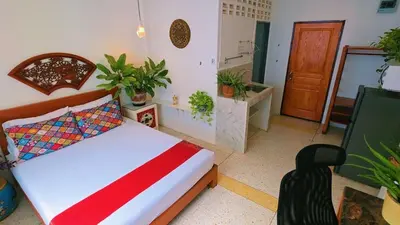 a bedroom with a bed and some plants in it at Lumphini 3 Teakwood red at Steamy Location in Bangkok