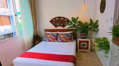 a bed in a room with plants and a window at Lumphini 3 Teakwood red at Steamy Location in Bangkok