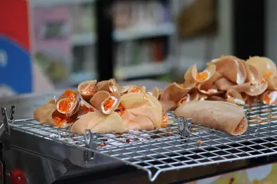 a metal grill with some food on it at Lumphini 3 Teakwood red at Steamy Location in Bangkok