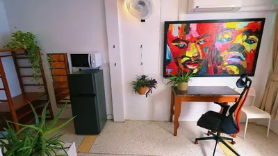 a room with a painting on the wall and a desk at Lumphini 7 Townhouse Master Authentic BKK Comfort in Bangkok