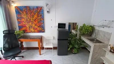 a kitchen with a desk and a painting on the wall at Lumphini Perfect Escape Sunny Rooftop EnSuite in Bangkok