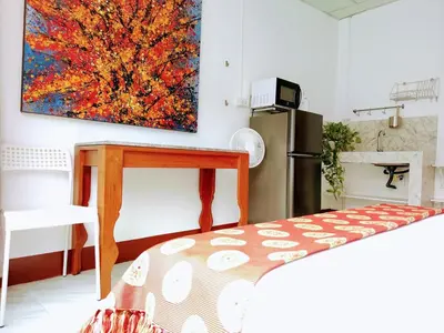 a kitchen with a table and a painting on the wall at Lumphini Perfect Escape Sunny Rooftop EnSuite in Bangkok