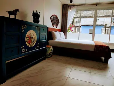 a bedroom with a bed and a dresser and a window at Lumphini Perfect Escape Sunny Rooftop EnSuite in Bangkok