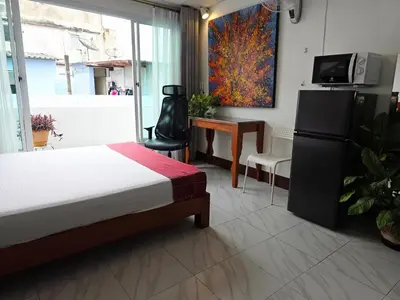 a bedroom with a bed and a desk and a tv at Lumphini Perfect Escape Sunny Rooftop EnSuite in Bangkok