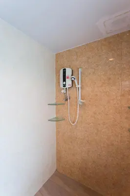 a shower in a bathroom with a brown wall at Cloud no 5 Generous space Green n Quiet Heart BKK in Bangkok