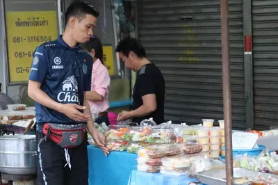 a man standing in front of a food stand at SKY 6 The Perfect Quiet Oasis BKK Center Near MRT in Bangkok