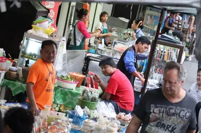 a group of people standing around a food stand at SKY 14 Vibrant street Cozy n Cool near center in Bangkok