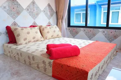 a bed with a red pillow on top of it at SKY 18 - 99 feet in the sky in Bangkok