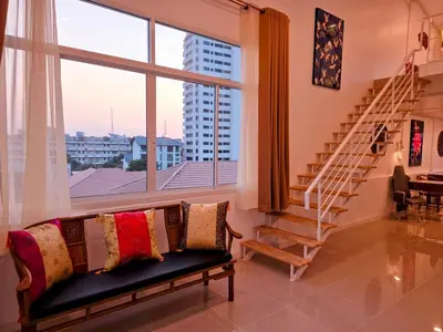 a living room with a couch and a large window at Crane nest 14 loft with views over Sathorn in Bangkok