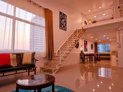 a living room with a spiral staircase and a table at Crane nest 14 loft with views over Sathorn in Bangkok