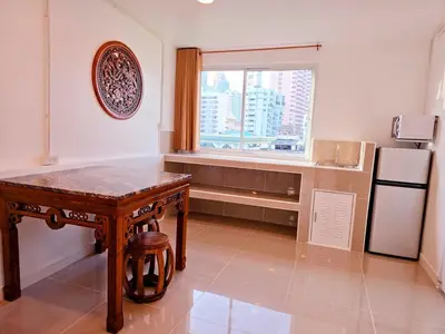 a kitchen with a table and a refrigerator and a window at Crane nest 14 loft with views over Sathorn in Bangkok