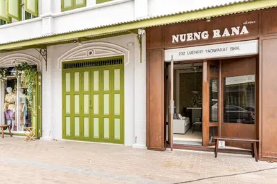 two store fronts with green doors on a street at Nueng Rana 232 Corner view 1BR Duplex 3beds / 2B in Samphanthawong