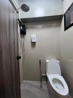 a bathroom with a toilet with a light on the wall at Apartment near Khlong Bang Luang in Bangkok