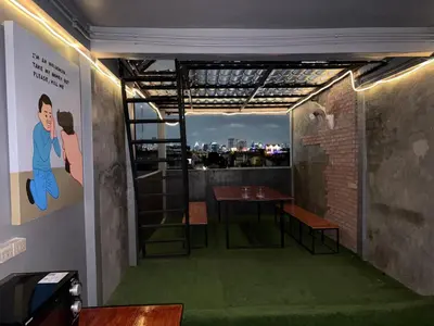 a room with a table and a view of a city at Nomad Yard Hostel in Bangkok