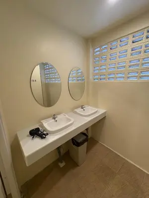 a bathroom with two sinks and two mirrors at Nomad Yard Hostel in Bangkok